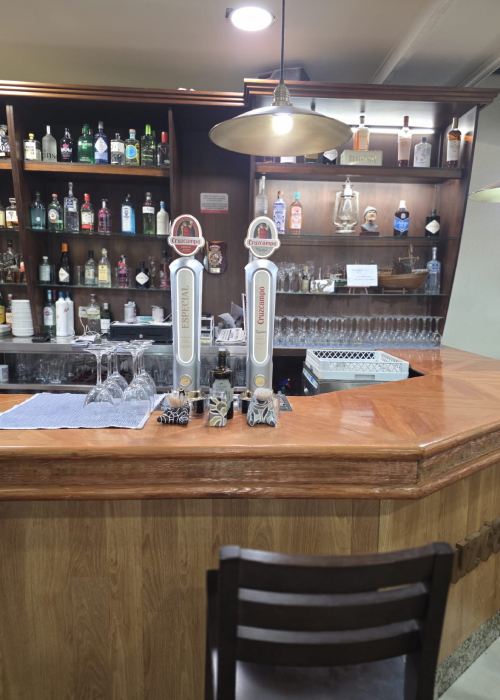 Restaurante Maluquer Quattro barra de bar con bebidas, copas y grifos de cerveza