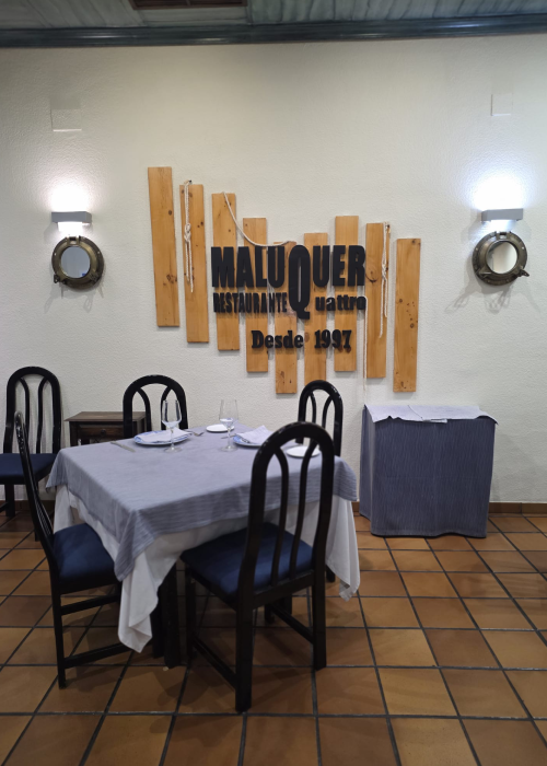 Restaurante Maluquer Quattro salón interior con mesa preparada y decoración marinera